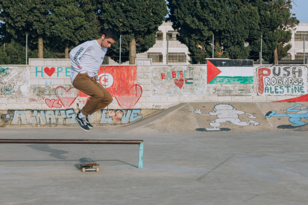 Skateboarding in the occupied west band surrounded by Palestinian graffiti