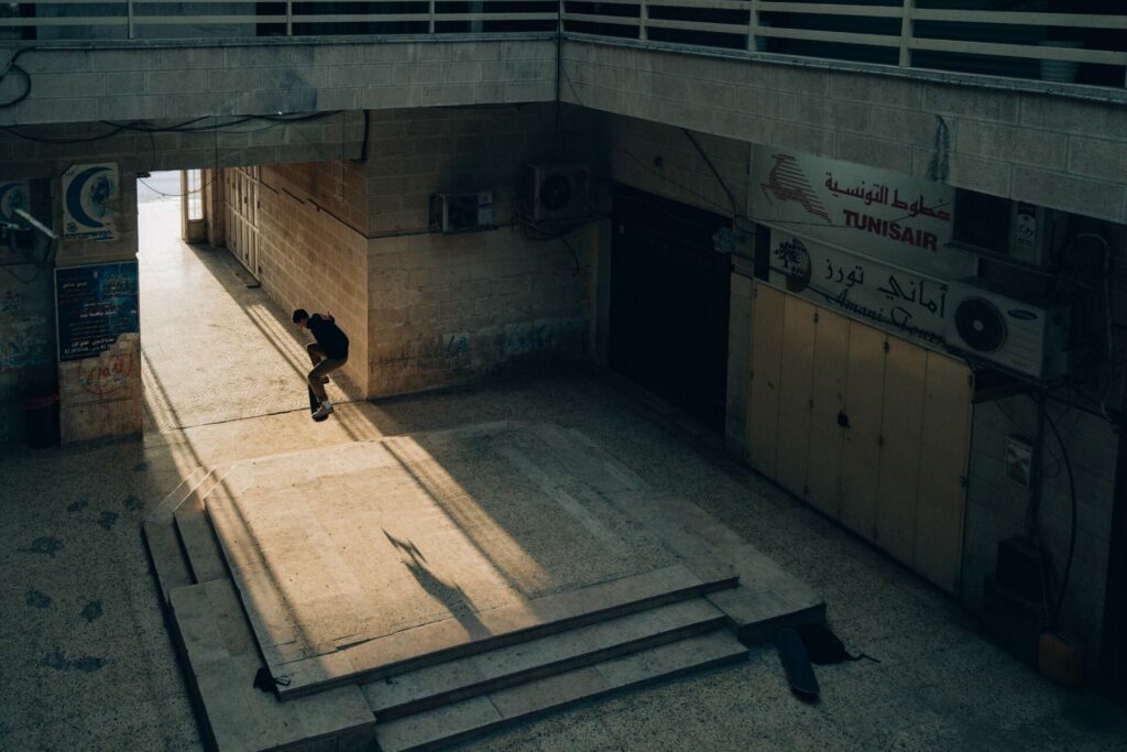 young man skateboarding in  stream of sunlight 