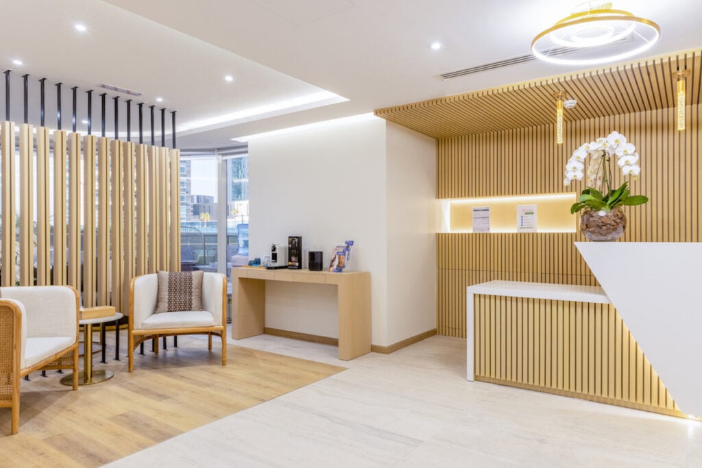 brightly lit reception of cornerstone clinic with large vase of white flowers on front desk 