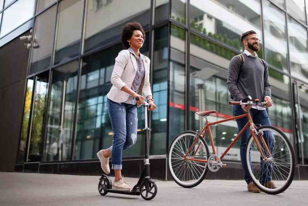 Couple on scooter and bike having fun and caring about climate change