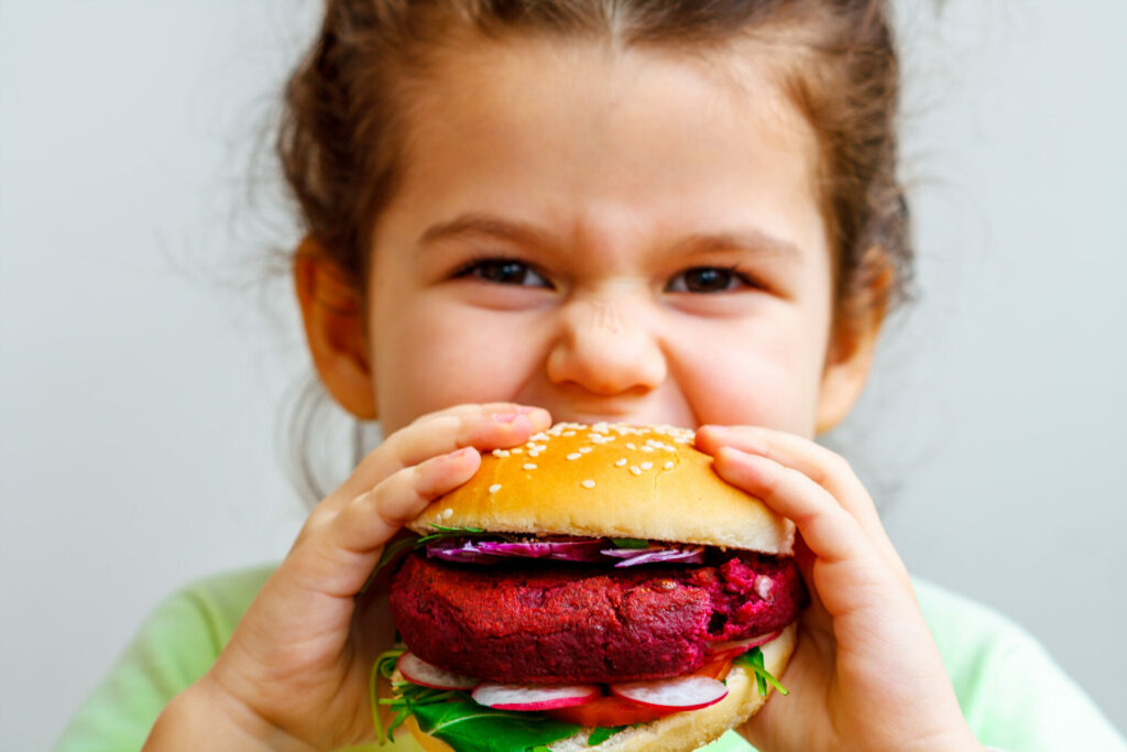 vegan child eating bean burger