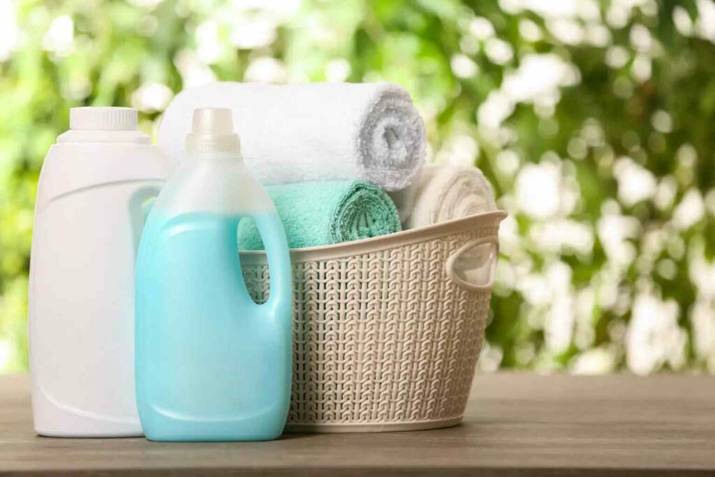 Two bottles of detergent next to laundry basket