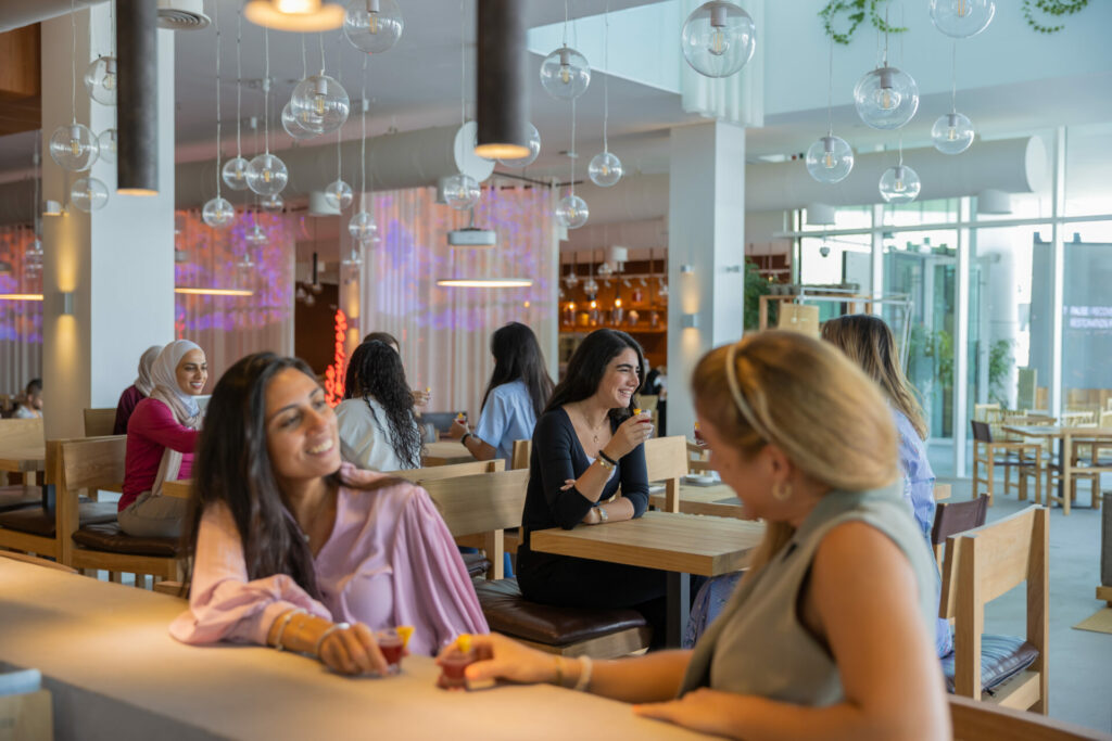 women chatting at different tables in a a cafe 