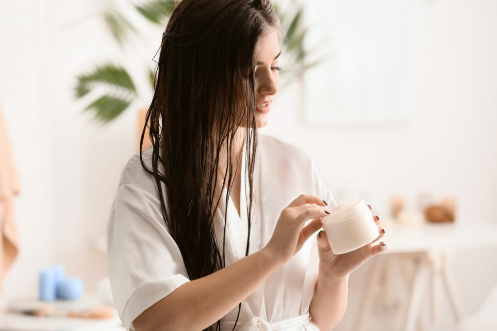 lady with wet hair applying haircare mask 