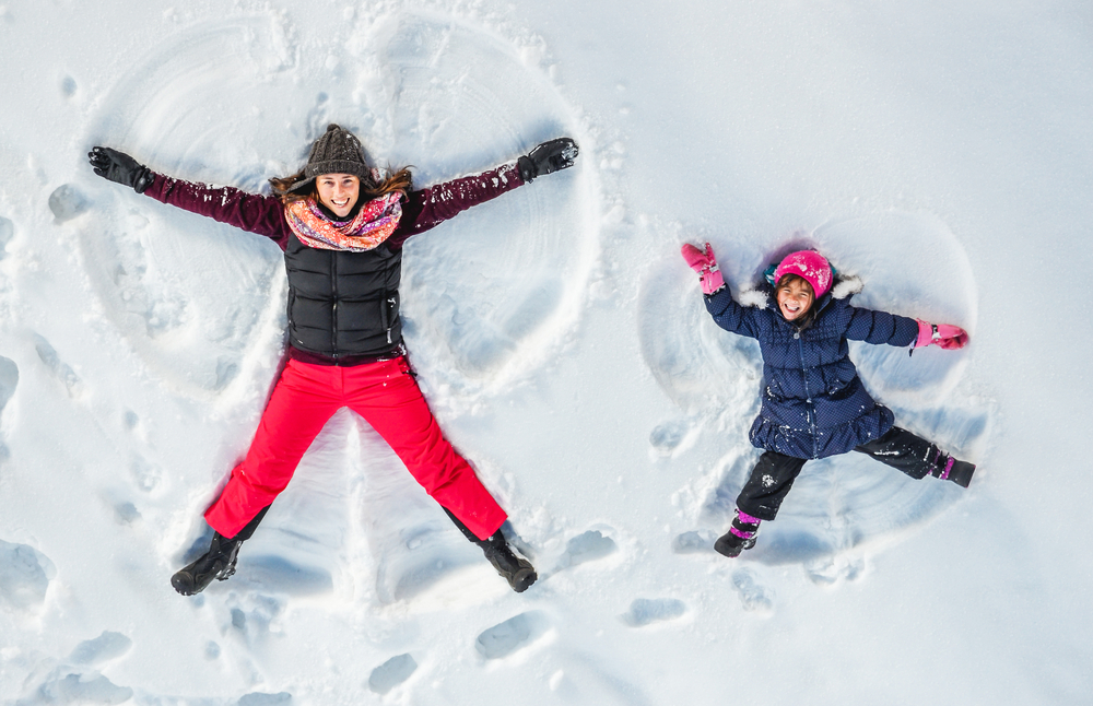 woman and child making snow angels as part of ending 2022 strong 