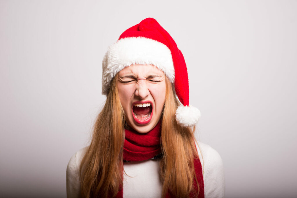 Christmas stress: woman screaming wearing festive hat