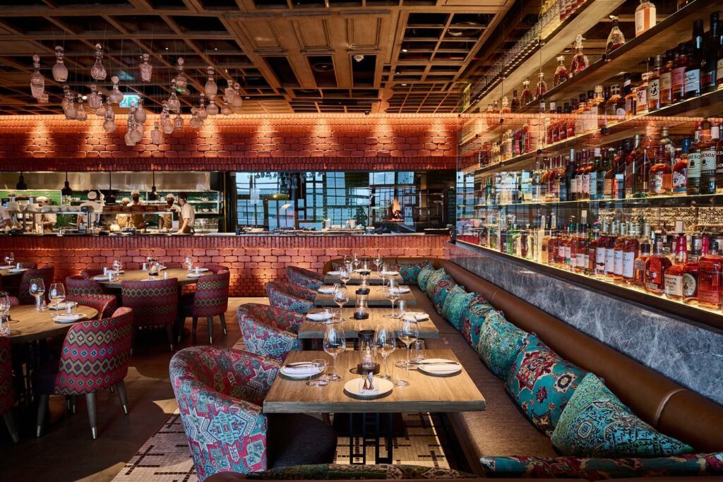 Turquoise and pink restaurant with glass cabinet full of bottles