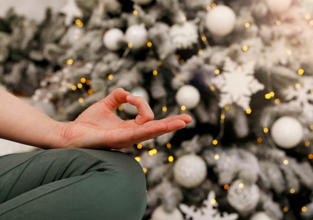 woman meditating by Christmas tree