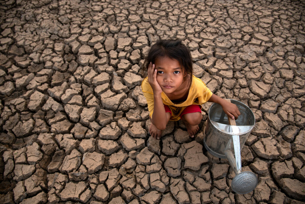 Girl with empty water can in drought because of climate crisis 