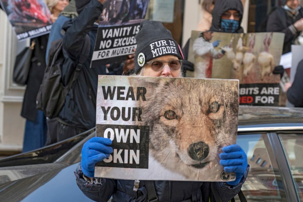 woman holding protest banner about killing animals for fur