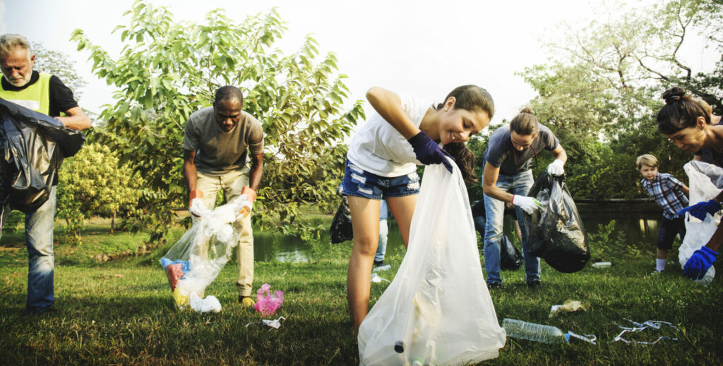 people being kind and picking up litter in park as act of kindness 