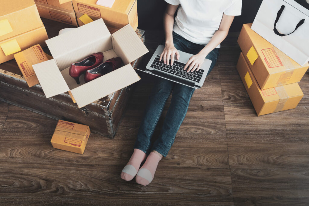 woman selling used clothes with boxes around her 