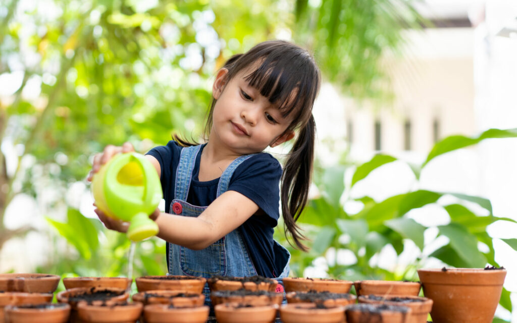 child watering plants 