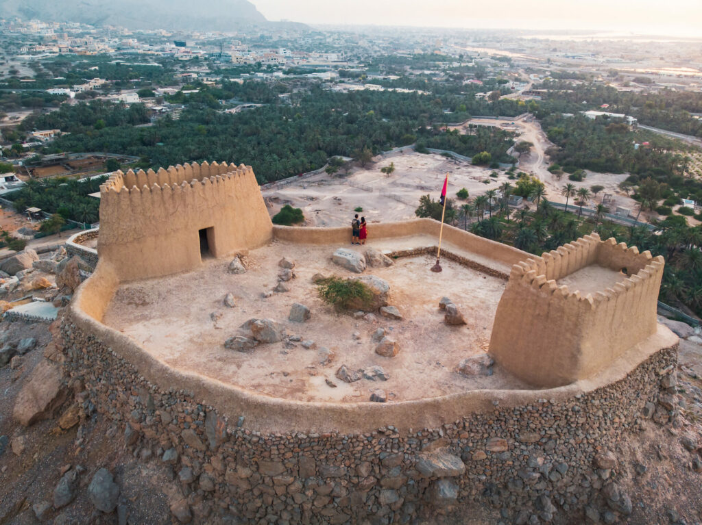 Couple at Dhayah Fort rock fortress in RAK, UAE at sunset for Valentine's Day idea