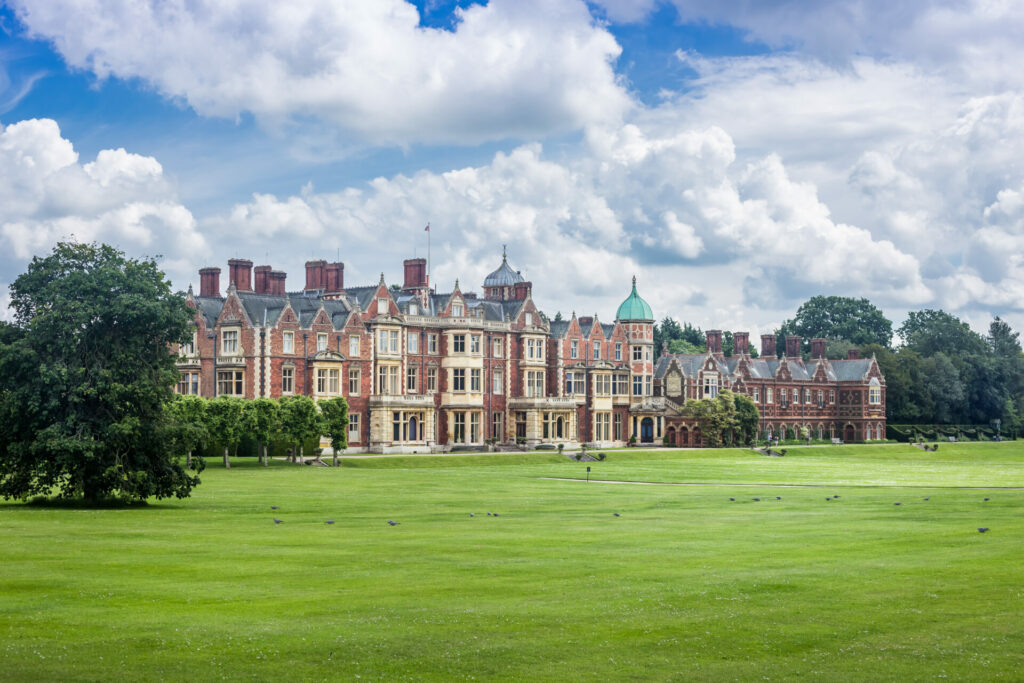 Sandringham house on a cloudy day with large expanse of pristine lawn in front 