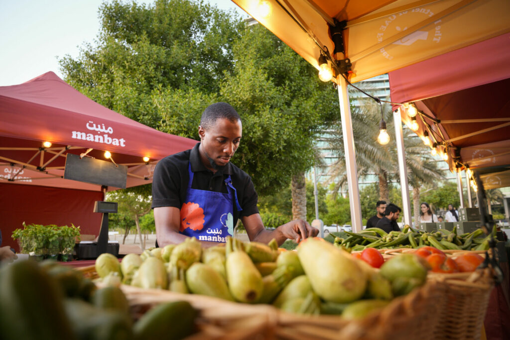 man arranging local produce at an outdoor market