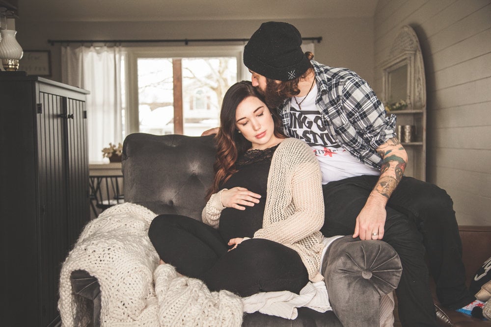 couple kissing on a large armchair 