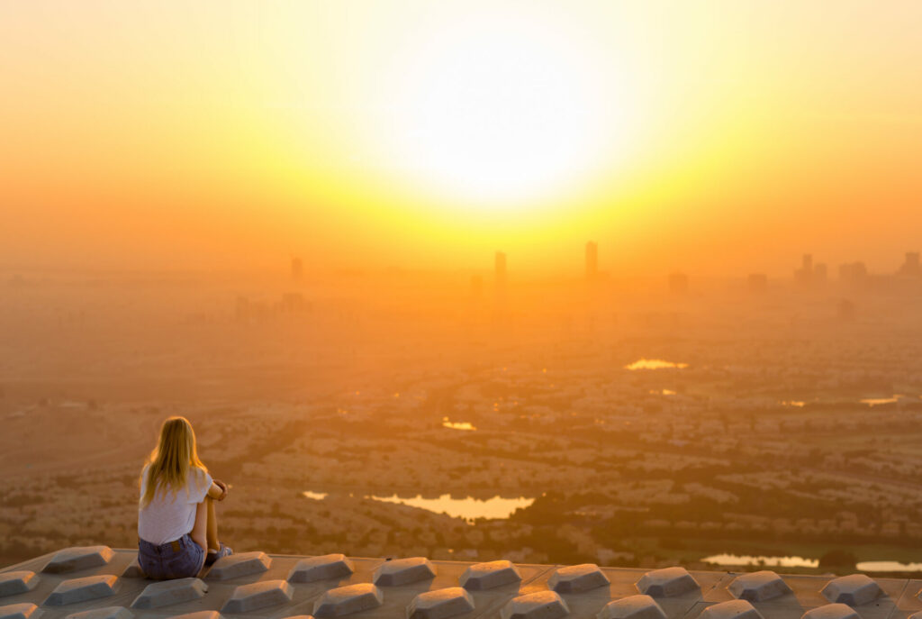 woman looking at city pollution over skyline - concept of climate crisis depression 