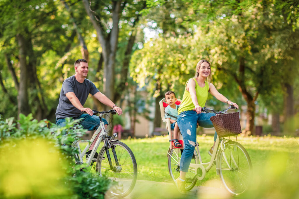 Happy family on bicycles  in park as an example of outdoor activities for kids 
