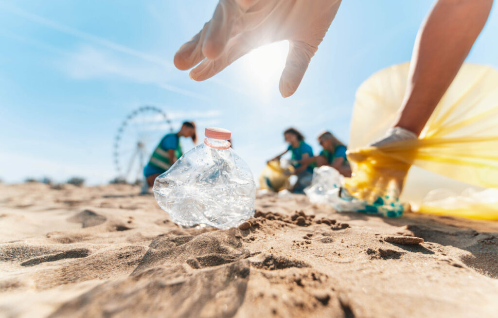 Group of eco volunteers picking up plastic trash on the beach 