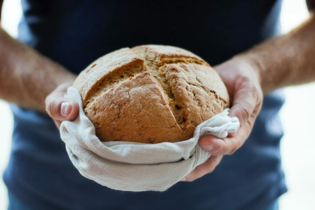 man carrying loaf of bread