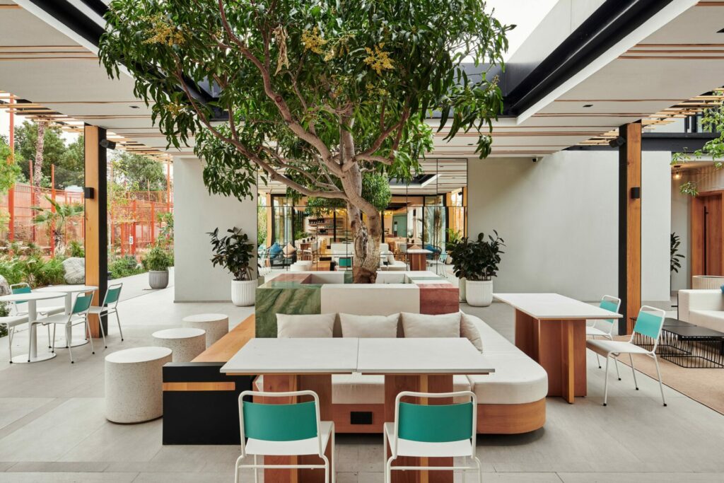 inside an airy restaurant with tree in the middle of the room