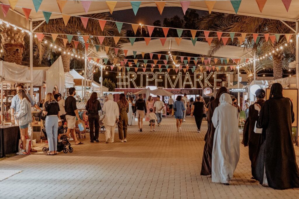 locals and expats meander through one of the UAE's many outdoor markets at night 