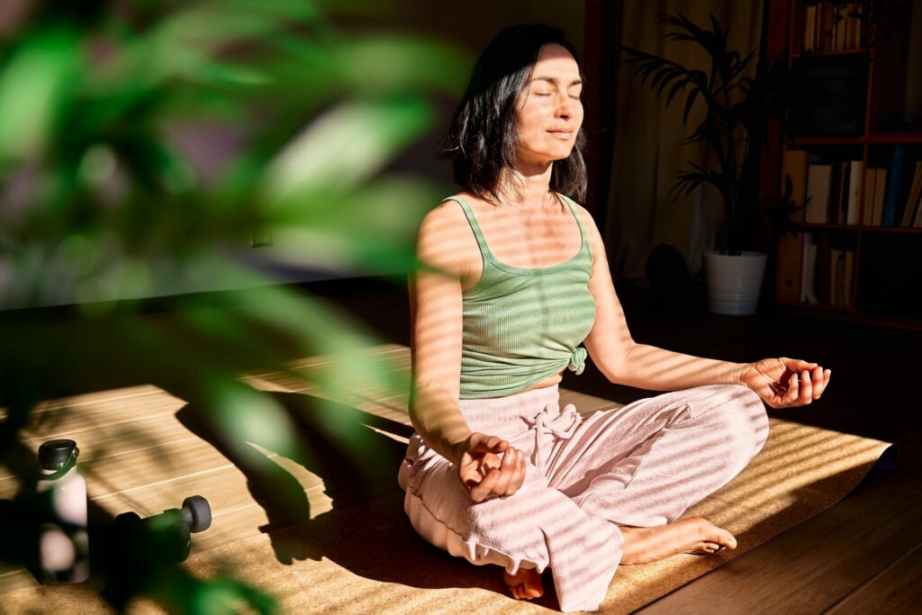 woman meditating near plants 