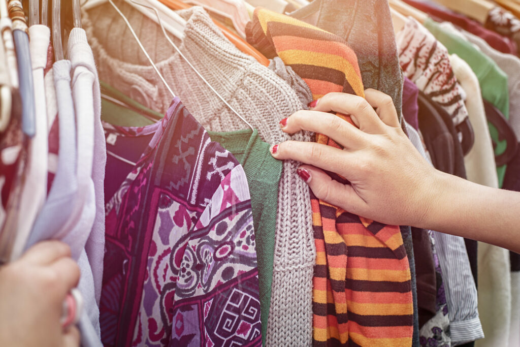 woman looking through second hand clothes 