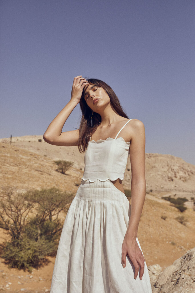 model looks hot and holds head in desert setting 