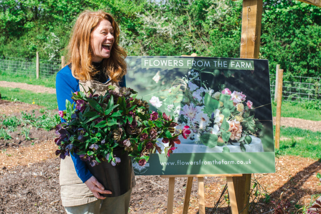 seasonal flowers in arms of gardening volunteer 