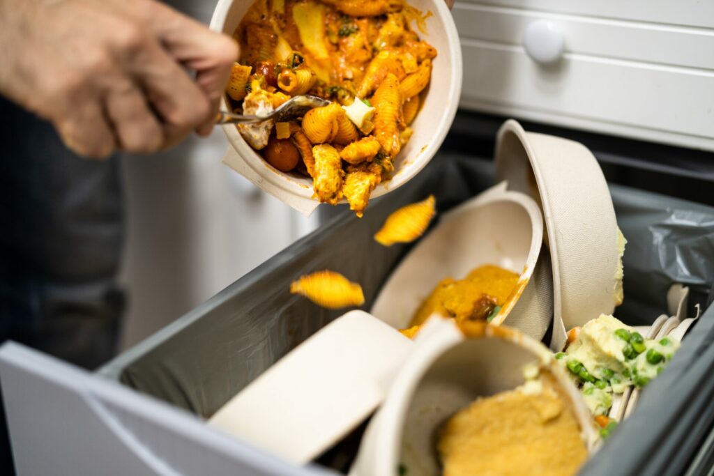 man throwing food waste into the bin