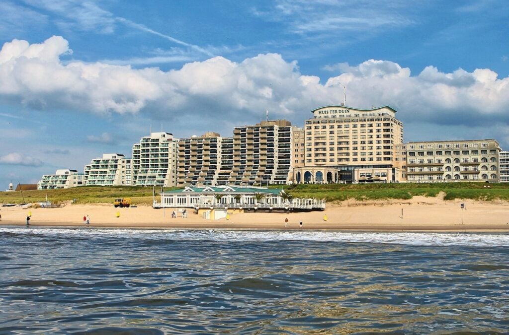 hotel on beach with blue skies and white clouds 