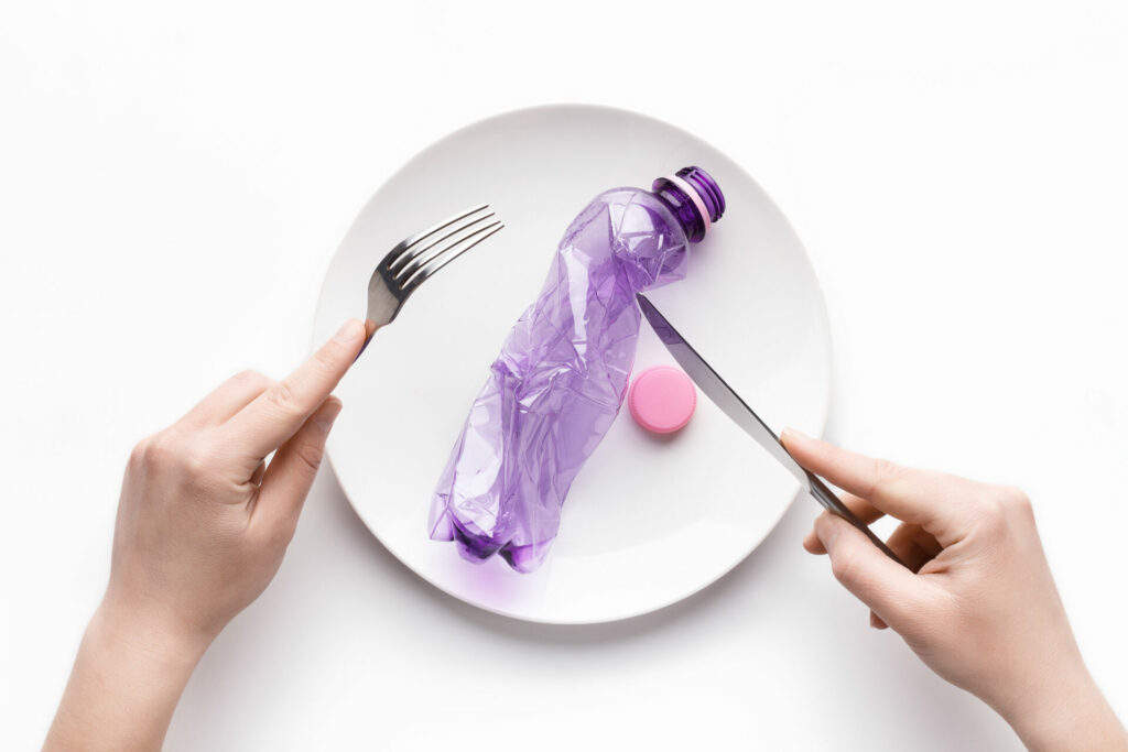 plastic bottle on a plate as concept of eating plastic pollution