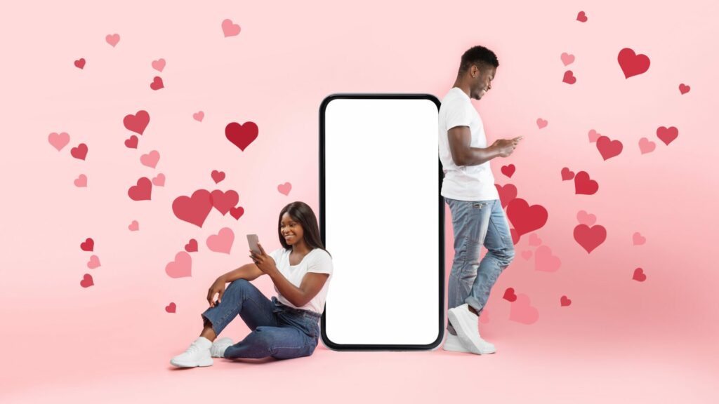 couple in textationship - texting each other with love emojis on giant mobile phone 