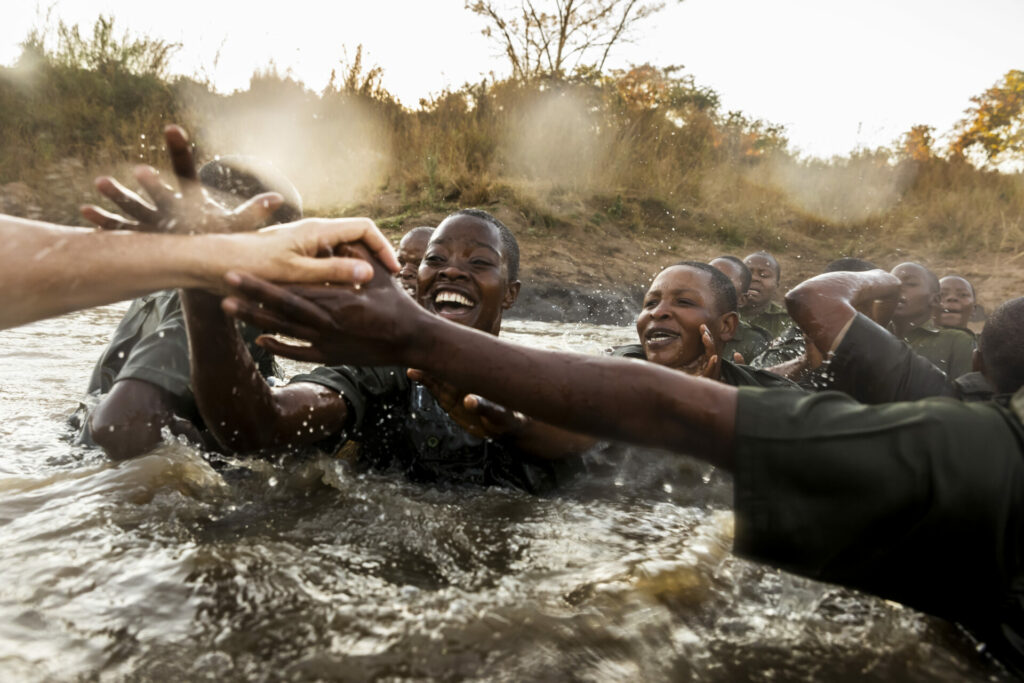 female rangers celebrating in water after passing tough training in the bush in Zimbabwe to join all-female Akashinga 