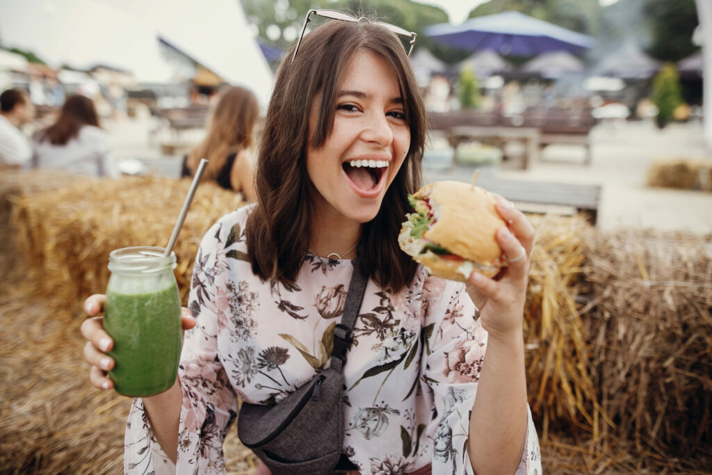 woman eating vegan burger as one of her ethical tweaks 