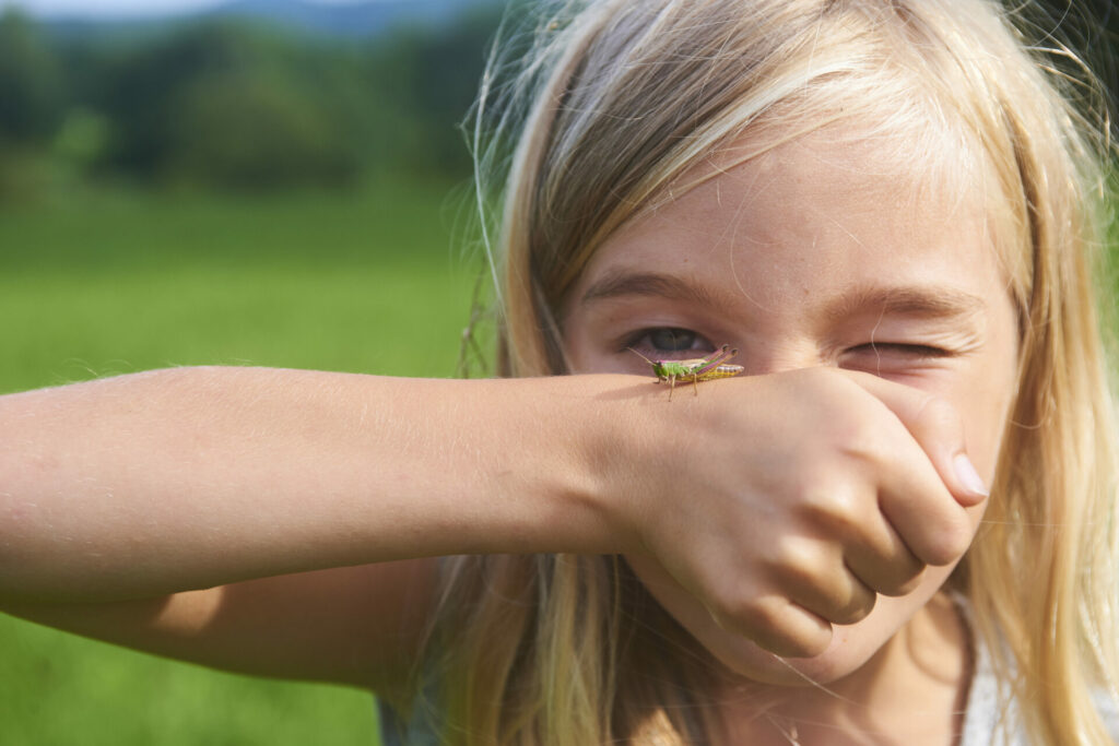 girl with insect on hand 