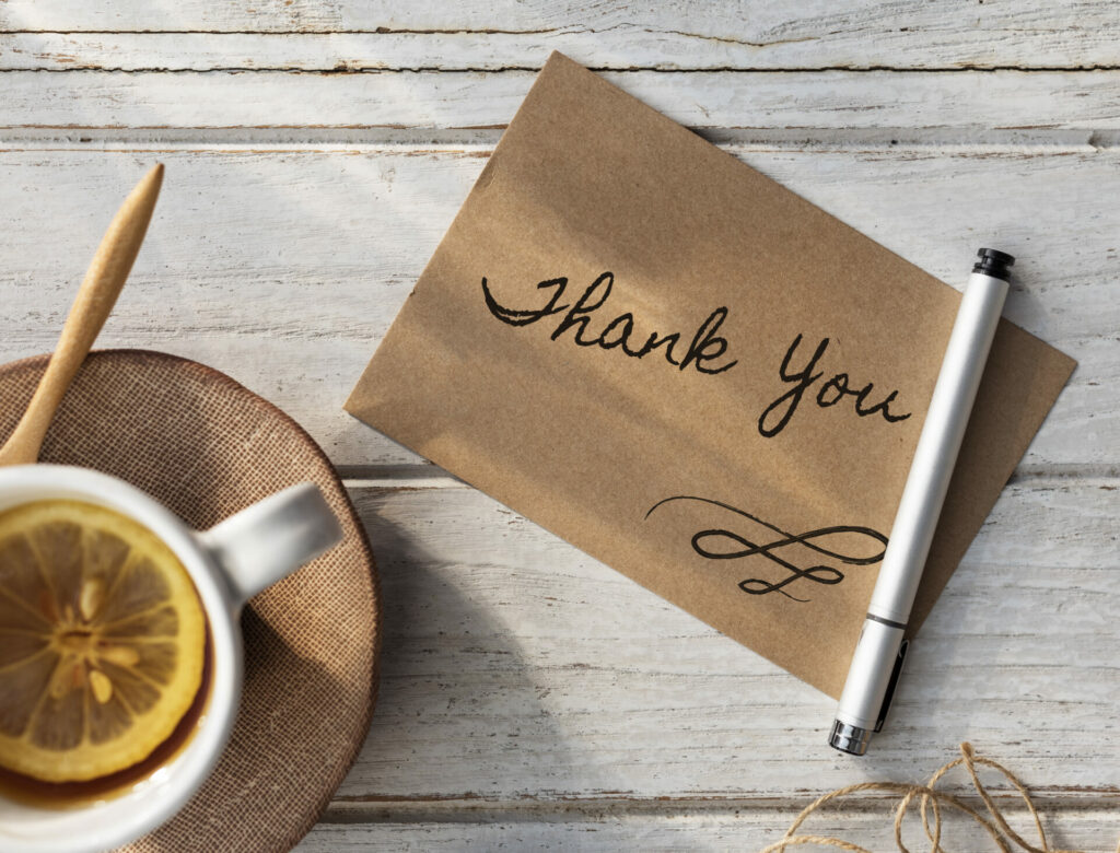 hand written thank you note next to cup of coffee 