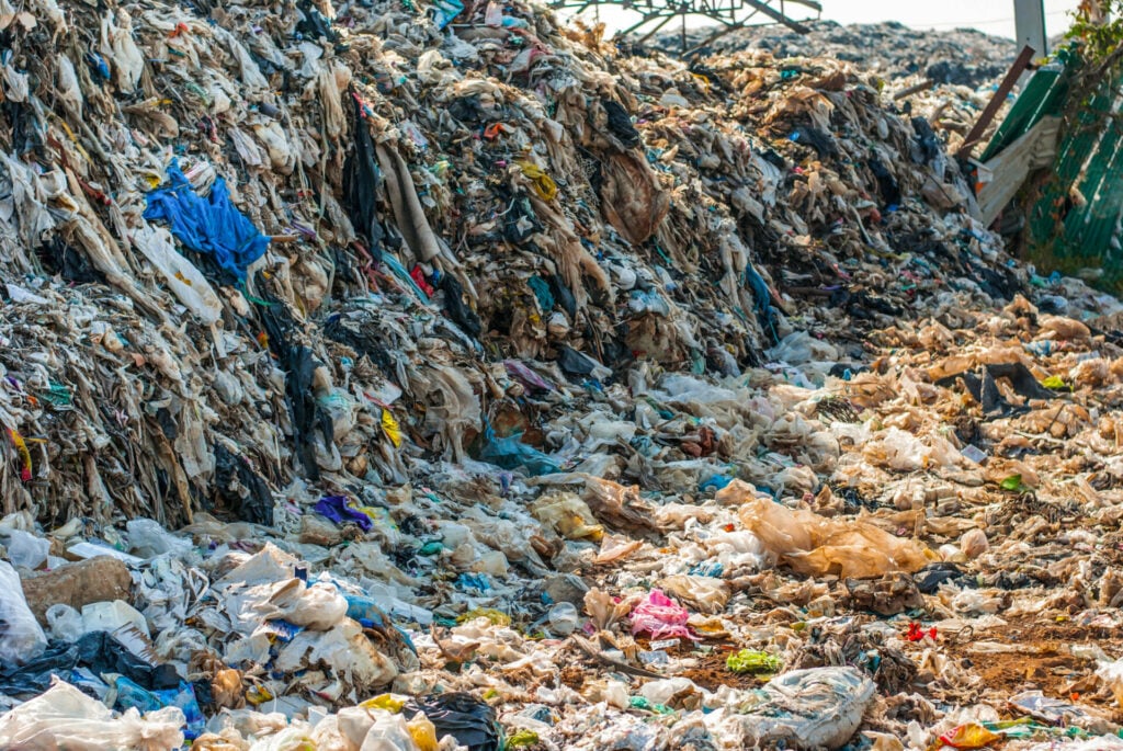 landfill site filled with discarded clothes 