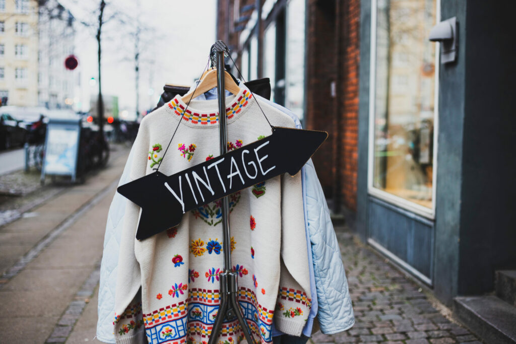 vintage sign in front of jumper and second hand clothes - response to fast fashion