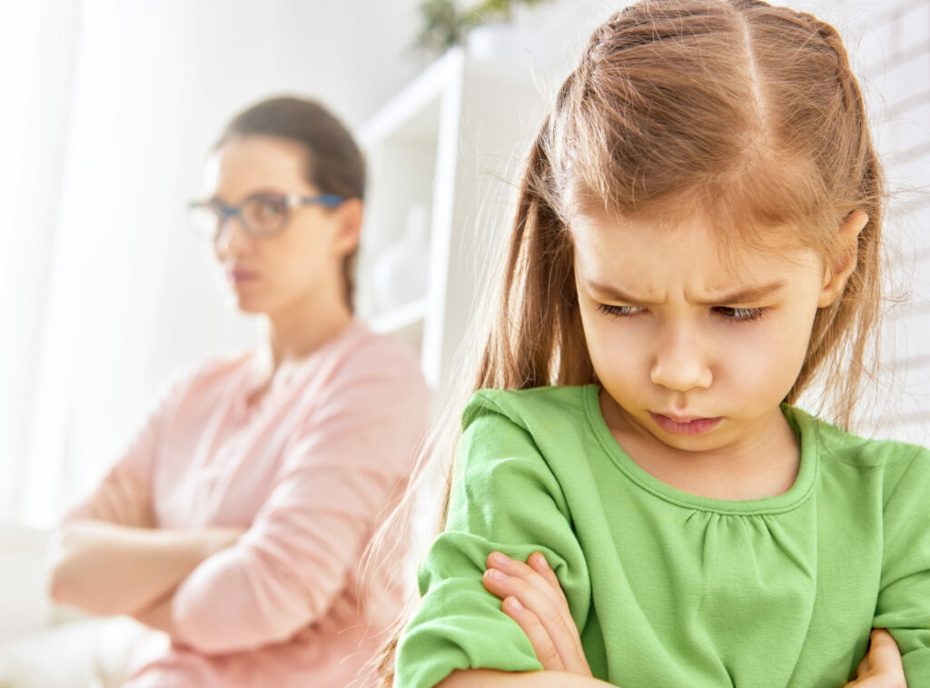 eggshell mum staring angrily at upset little girl