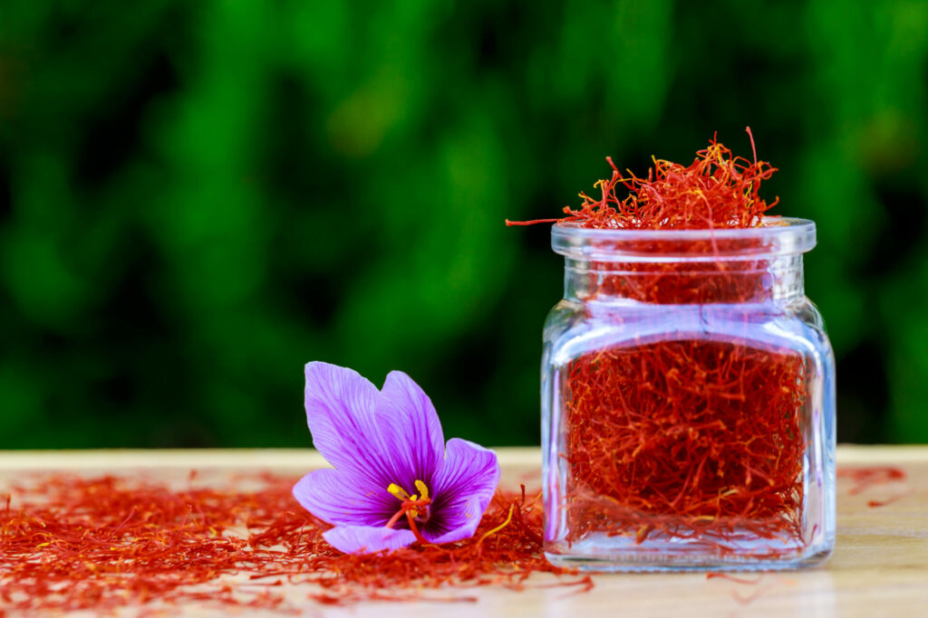 saffron in a glass jar with purple flower 