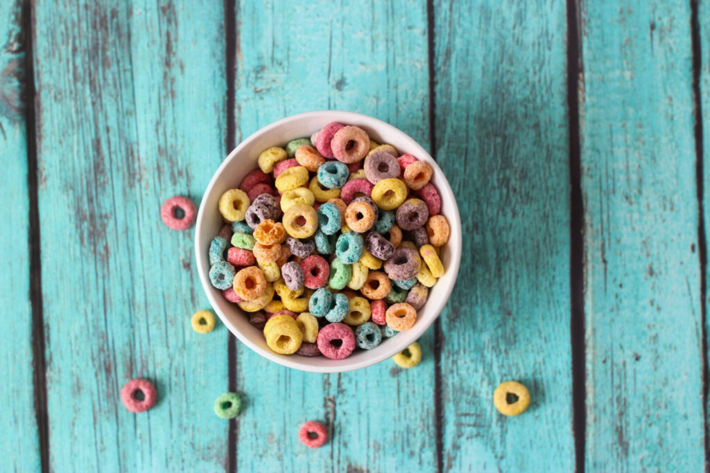 bowl of rainbow puff cereal on blue wood background 