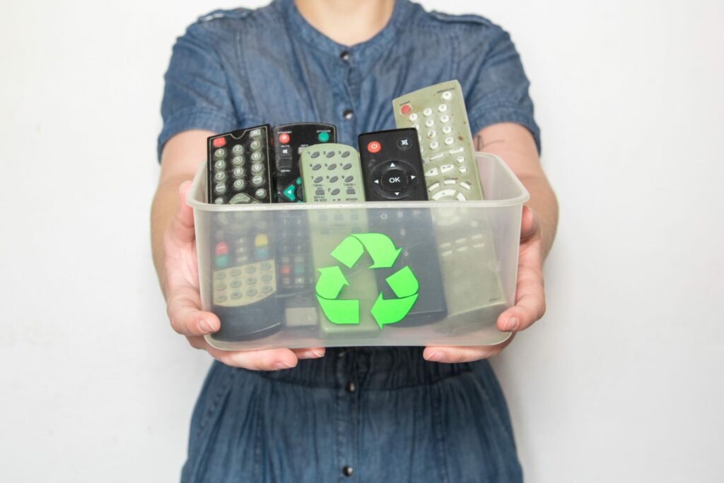 woman holding box of typical fasttech gadgets, remote controls 