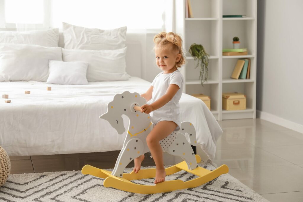 blonde toddler on a wooden rocking horse, the perfect eco gift 