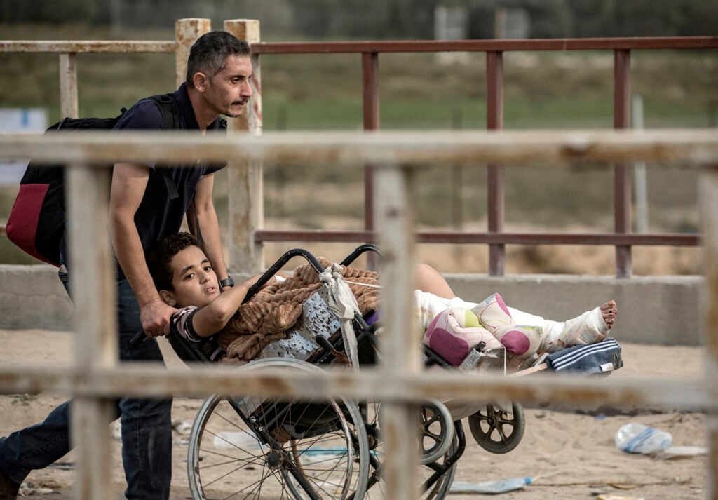 a man pushes his injured son in Gaza, Palestine 
