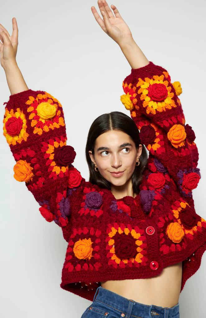 lady in embroidered jumper with her hands in the air 