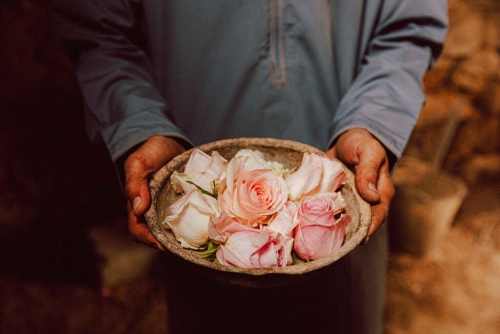 a person holding a bowl of rose petals at Alila Jabal Akhdar