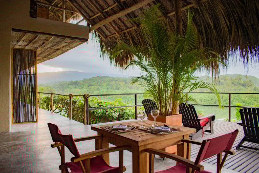 a table and chairs under a thatched roof in the restaurant at Finca Barlovento